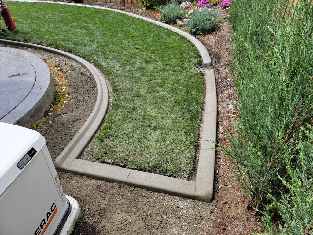 A photo of curbing with some detail work around a drainage grate