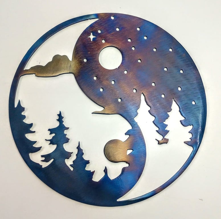 Metal art of a yin yang symbol with a night sky and trees interpolated into it