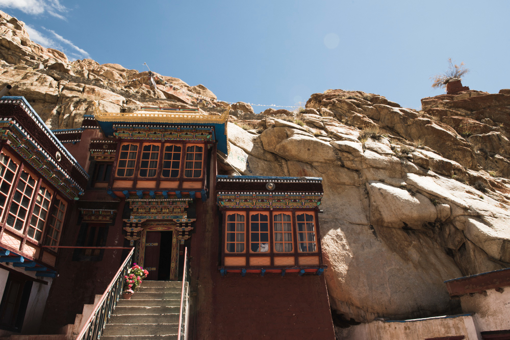 Walled city of Lo Manthang under blue sky with red canyon cliffs behind, Upper Mustang, Nepal