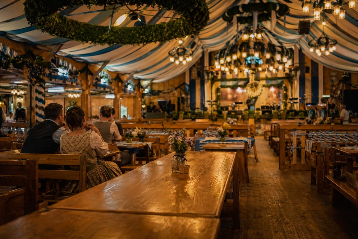 Oktoberfest beer tent interior in Munich with packed benches, steins raised, and traditional Bavarian decorations overhead, Theresienwiese, Munich, Germany