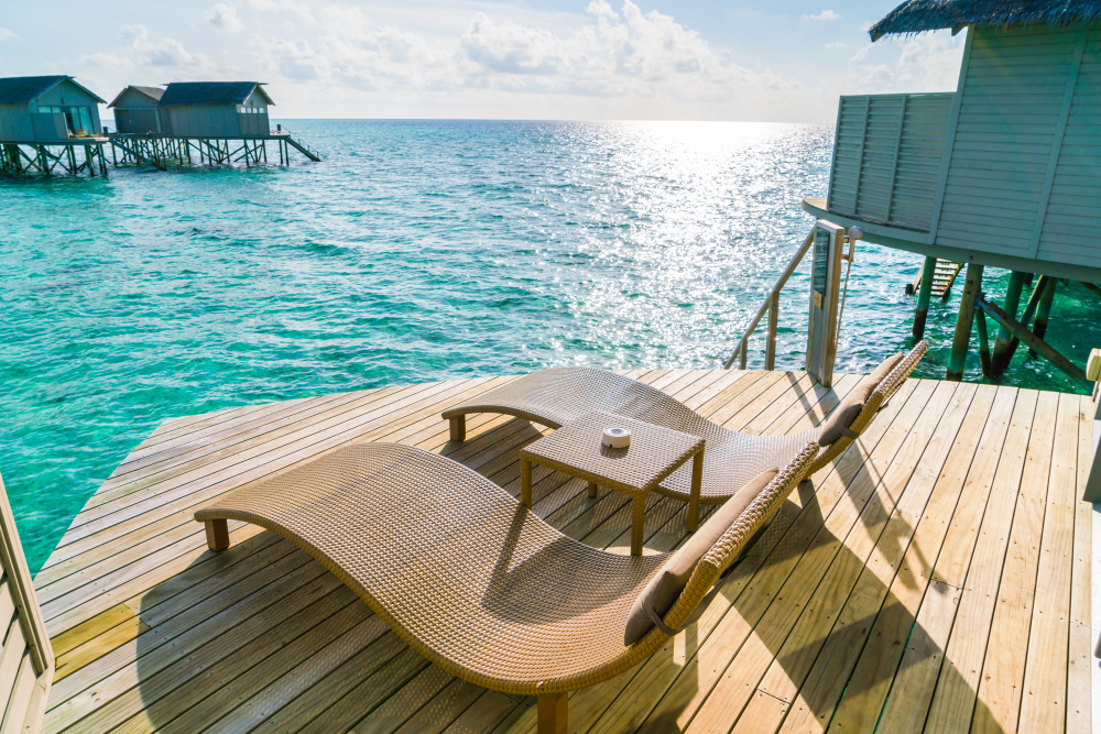 Aerial view of overwater bungalows on a wooden pier above a turquoise lagoon, South Male Atoll, Maldives