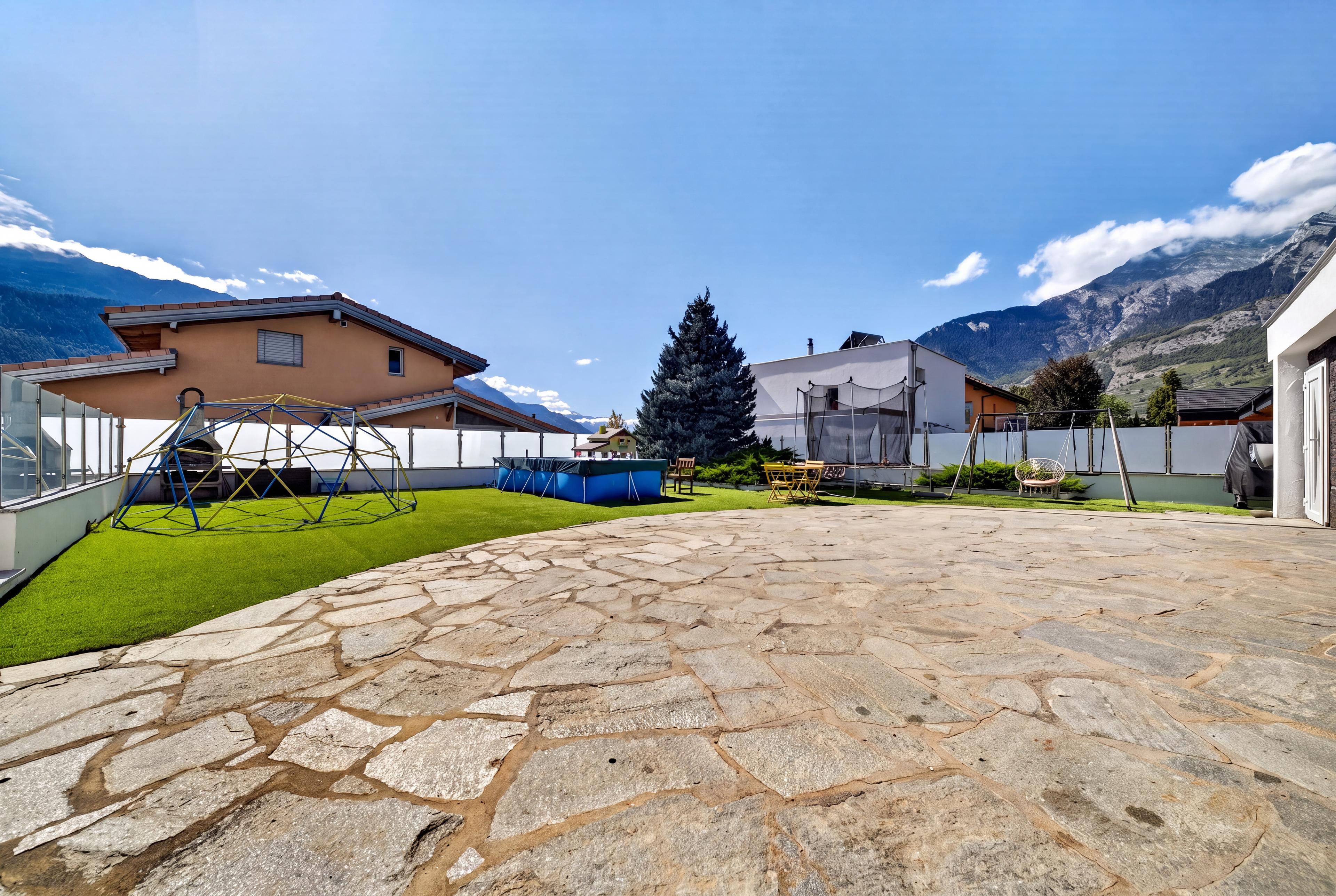 Vue de la terrasse avec la pelouse devant la villa