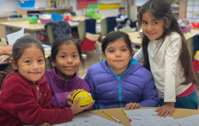 Four Kids in Classroom Smiling