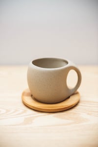 Ceramic teacup and wooden saucer