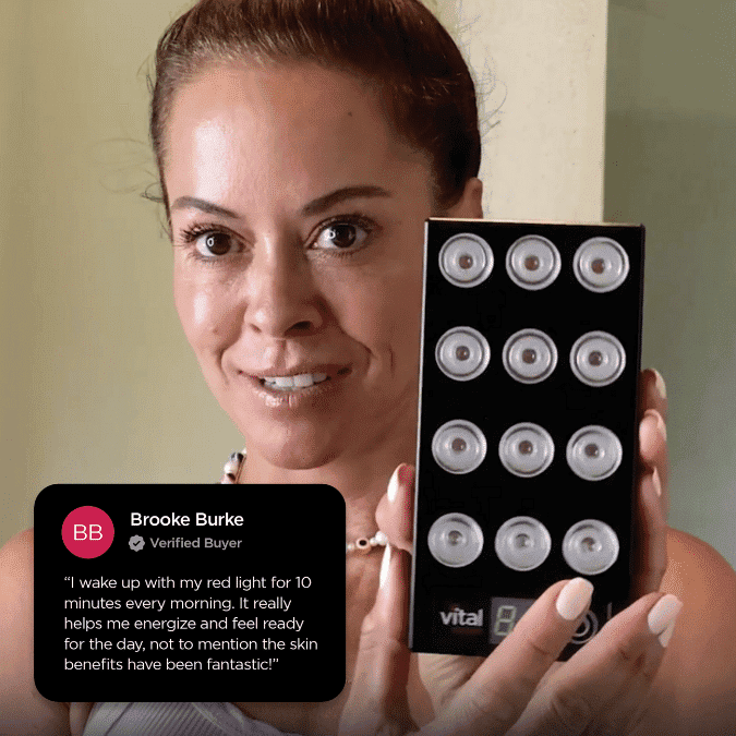 A person holding a handheld red light therapy device with multiple circular lights. A review beside them praises its benefits for vital charge, boosting energy, enhancing readiness, and improving skin.