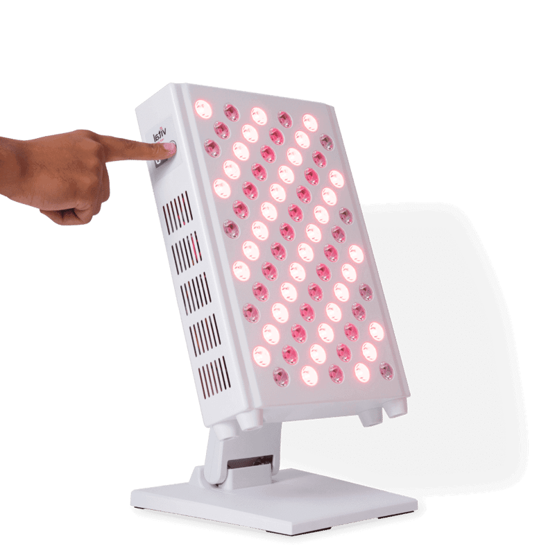 A hand presses the button on a sleek, rectangular light therapy device, its multiple illuminated red lights showcasing the rejuvenating red light therapy benefits. The device is elegantly mounted on a stand, ready to enhance wellbeing.