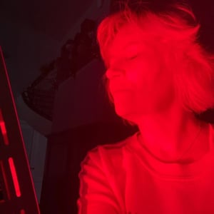 a mature woman using red light therapy to treat her arthritis