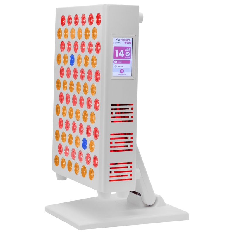 The Vital Elite 2.0 is a white electronic device with red, amber, and blue lights on the front and a digital display screen on the right side, mounted on a stand. It's ideal for those interested in red light therapy lights.