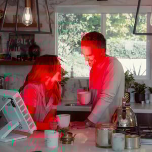 A couple enjoying coffee while using their Vital Pro red light therapy device