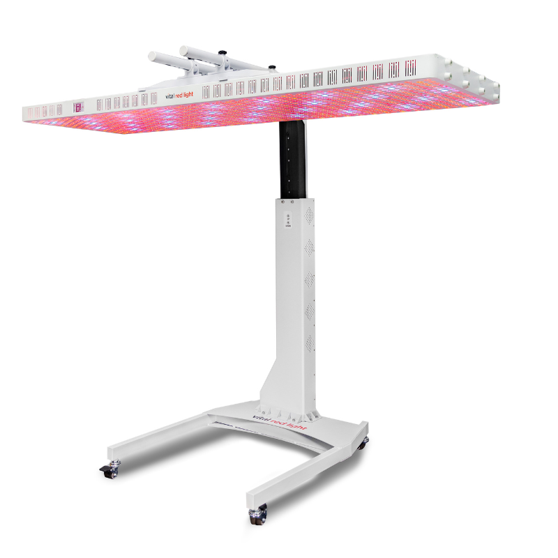 Vital Red LIght. Red Light Therapy. The Motorized Stand holds a large rectangular red light therapy device with adjustable height and LED panels that emit red and blue light.