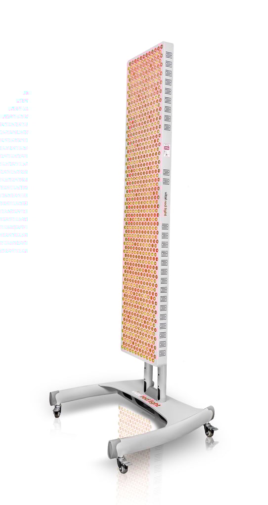 Vital Red LIght. Red Light Therapy. A tall, rectangular red light therapy panel with multiple LED bulbs, mounted on a wheeled, white stand—perfect for your home or any red light therapy shop seeking vital elite equipment.
