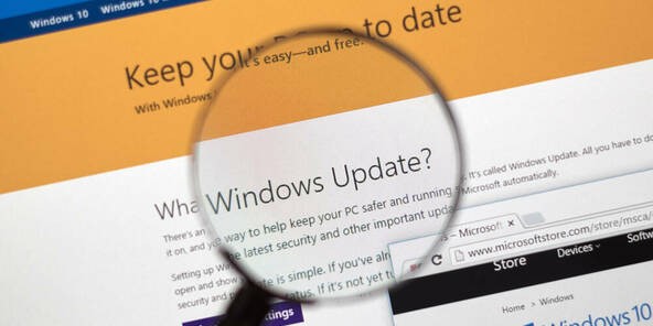 TechDogs-"Windows 11 Patch Tuesday Breaks For Virtual Machines"-"Magnifying Glass Over Windows Update Page on Microsoft Website"