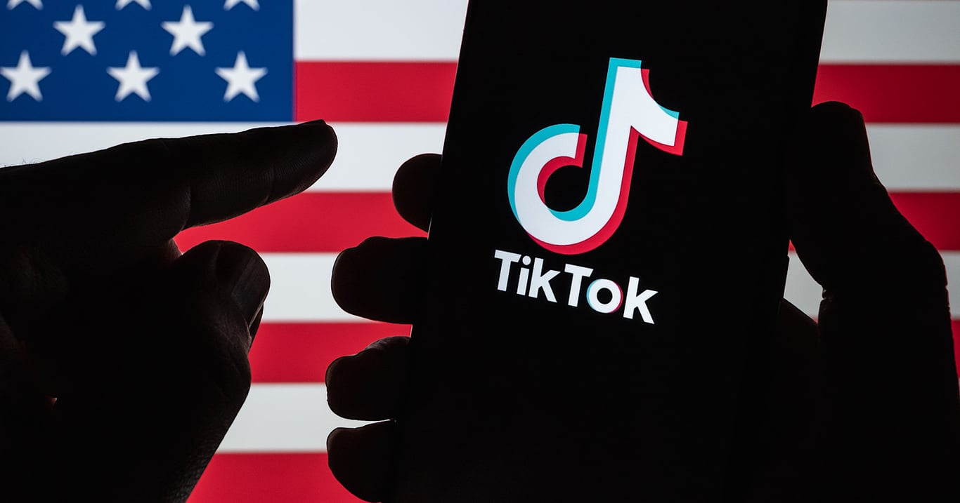 TechDogs-"An Image Of TikTok's Logo On A Phone In Front Of The US Flag"