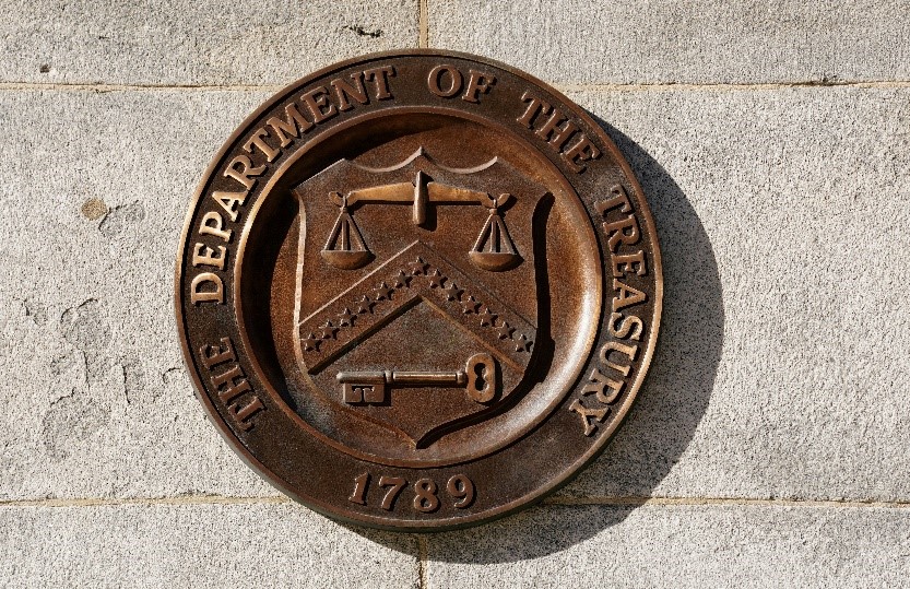 TechDogs-"What Steps Has The Treasury Department Taken?"-"The Department Of The Treasury Seal On A Stone Wall, Featuring Scales, A Key, And The Year 1789"