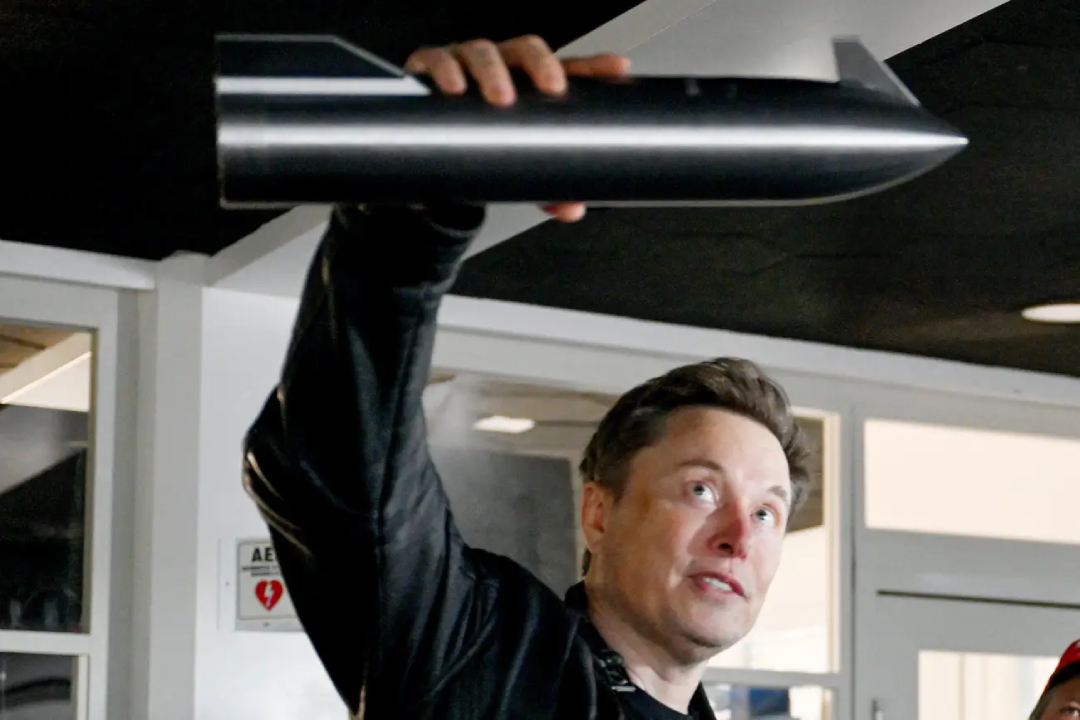 TechDogs-"Elon Musk Holding A Rocket Model At SpaceX Facility"