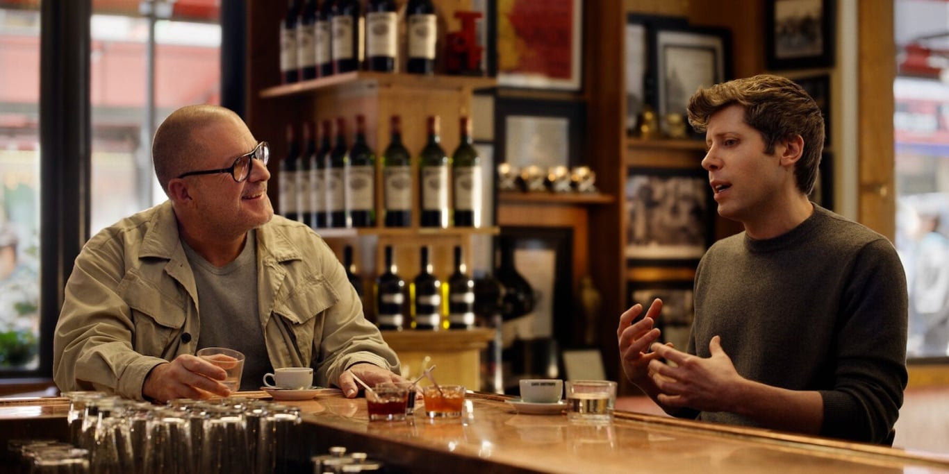 TechDogs-"What’s Happening With OpenAI And Jony Ive’s Lab?"-"Am Altman And Jony Ive Discussing AI Over Coffee At A Bar Counter"