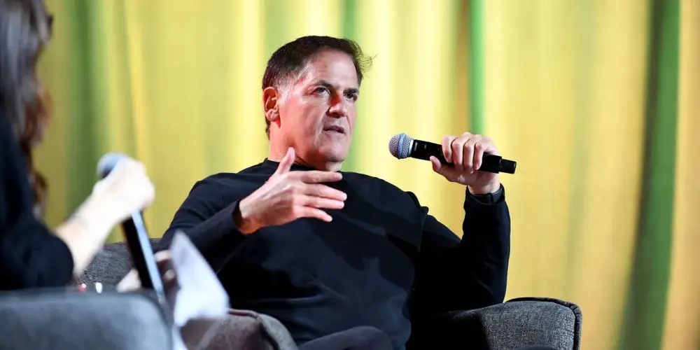 TechDogs-"Mark Cuban Says AI Will Create Jobs, Not Cut Them"-"Mark Cuban Speaking Into Microphone During Live Panel Discussion"