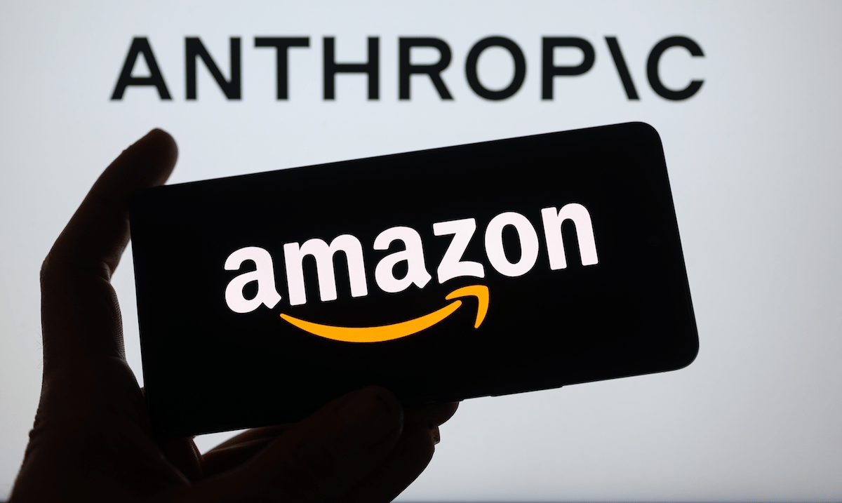 TechDogs-"An Image Of Anthropic's Logo In The Background And Amazon's Logo On A Phone"