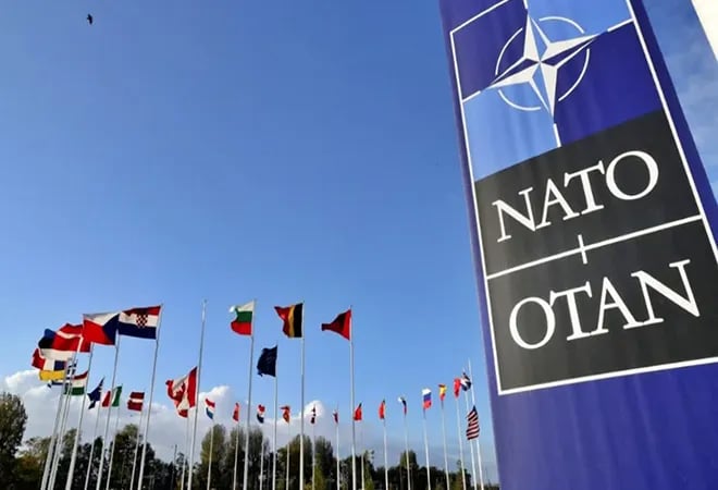 TechDogs-"An Image Of NATO's Logo Along With The Flags Of Its Member Countries"
