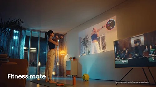 TechDogs-"Interactive Projection"-"Woman Working Out With Samsung Ballie Projecting Fitness Video on Wall"