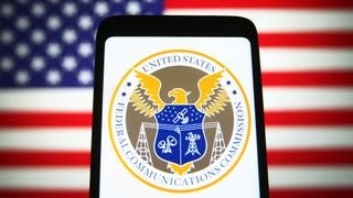 TechDogs-"What Did The FCC Announce?"-"FCC Logo Displayed On A Smartphone Against A U.S. Flag Background"