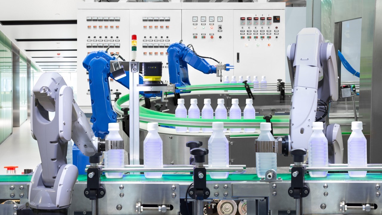 TechDogs-"What Are Polyfunctional Robots?"-"Polyfunctional Robotic Arms Operate On An Automated Production Line, Handling Bottles With Precision In A Modern Industrial Facility."