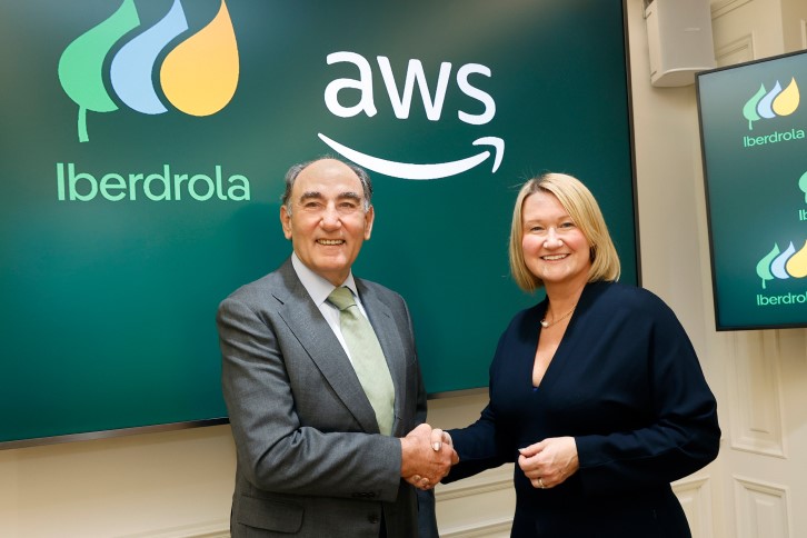 TechDogs-"Image Of Iberdrola CEO Ignacio Galán And AWS VP Janice Zdzarski Shake Hands Before A Screen With Both Logos, Marking Their Renewable Energy Partnership."