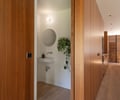 Preview of Ainslie Remodel and Addition - Image 5: bathroom, wood paneling, floating sink, mirror, wood floor, modern design, interior lighting, recessed lighting, indoor plant, wood cabinetry.