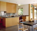Preview of Bruckner Residence - Image 11: Dining Table, Furniture, Table, Indoors, Interior Design, Kitchen, Room, Chair, Dining Room, Window, wood cabinets, stainless steel backsplash, concrete floor.
