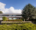 Preview of Casper Residence - Image 0: Roland Terry, historic, modern, residential, landscape, stone wall, wood siding, large windows, flat roof, minimalist, contemporary, urban, garage door, shrubs, trees, pathway, two-story, facade, natural light.