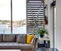 Preview of Floating Home - Image 17: Flora, Jar, Plant, Potted Plant, Pottery, Vase, Couch, Furniture, Indoors, Interior Design, Studio Couch, Wood ceiling, Indoor, Wood wall.