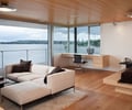 Preview of Graham Residence - Image 14: Indoors, Interior Design, Couch, Furniture, Coffee Table, Table, Light Fixture, Indoor, Waterfront, Great room, Wood floor, Wood ceiling, Lighting, Exterior glass.