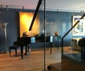 Preview of Hanna Condominium - Image 0: Grand Piano, Leisure Activities, Music, Musical Instrument, Piano, Chair, Furniture, wood floor, stair, glass rail.