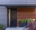 Preview of Vashon Island Cabin - Image 7: modern, contemporary, minimalist, black steel, wood siding, metal siding, pivot door, entrance, outdoor plants, landscaping, linear design, residential architecture, sustainable, urban, textures, natural materials.