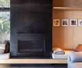 Preview of Vashon Island Cabin - Image 11: modern, contemporary, black steel, structure wood, wood paneling, open shelving, minimalist, natural light, large windows, built-in seating, custom fireplace, living room, ceiling beams, glass coffee table, cozy, warm tones, residential design, texture contrast.