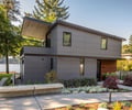 Preview of Vashon Island Cabin - Image 2: modern, contemporary, minimalist, urban, waterfront, structure wood, cantilever, concrete walkway, large windows, flat roof, steel accents, landscaped garden, exterior cladding, geometric design, sustainable, green building, wood paneling, natural lighting, residential architecture, patio, outdoor living space.