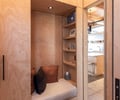 Preview of Vashon Island Cabin - Image 15: wood paneling, built-in seating, shelving, storage, recessed lighting, modern, contemporary, minimalist, natural wood, interior design, cozy nook, textured pillows, neutral colors, open shelving, concrete floor, residential design, light fixtures, architectural details, functional space.