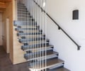 Preview of Vashon Island Cabin - Image 18: stair, modern, minimalist, structure steel, structure wood, floating stairs, black steel, wood ceiling, metal railing, open risers, natural light, indoor staircase, contemporary design, concrete floor, interior architecture, residential design.