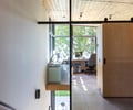Preview of Vashon Island Cabin - Image 19: stairs, concrete floor, wood panel ceiling, glass wall, office space, natural light, modern, minimalist, interior design, railings, frosted glass, sliding door, wooden cabinetry, black steel accents, large windows, urban..