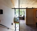 Preview of Vashon Island Cabin - Image 21: stair, home office, wood ceiling, glass wall, concrete floor, modern, minimalist, natural light, workspace, interior design, railing, window view, sustainable, contemporary, structure wood.