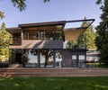 Preview of Vashon Island Cabin - Image 0: modern, contemporary, structure wood, large windows, deck, outdoor seating, glass railing, wood siding, cantilever, minimalist, black steel, flat roof, sustainable, green building, urban, residential, landscaped garden, patio, natural light, wooden steps.