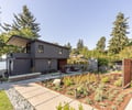 Preview of Vashon Island Cabin - Image 5: modern, contemporary, waterfront, concrete path, landscaped garden, flat roof, large windows, horizontal siding, deck, outdoor living, privacy screen, wood accents, urban, residential architecture, natural lighting, two-story, exterior design, sustainable landscaping.
