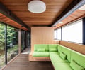 Preview of KITCHEN CONNECTED - Image 4: wood ceiling, exposed beams, large windows, glass wall, natural light, wood paneling, green upholstery, built-in seating, modern design, indoor-outdoor connection, dark wood floor, minimalist lighting, window frames, interior design, architectural feature.