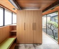Preview of KITCHEN CONNECTED - Image 5: wood paneling, large windows, sliding door, natural light, built-in shelving, stone flooring, exterior view, modern design, wood ceiling, storage cabinet, minimalist, indoor/outdoor connection, green cushion, wooden beam, natural materials.