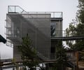 Preview of Lagerberg Mooring - Image 20: modern, contemporary, industrial, urban, stair, structure steel, steel mesh, glass railing, cantilever, exterior, facade, balcony, metal cladding, greenery, overcast, minimalist design, architectural design, pedestrian bridge, urban setting, raised structure, waterfront.