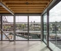 Preview of Lagerberg Mooring - Image 10: glass walls, exposed beams, metal framing, wood ceiling, concrete floor, bridge, railing.