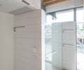 Preview of Lagerberg Mooring - Image 17: bathroom, glass door, wall tiles, concrete floor, wood beams, natural light, modern design.