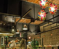 Preview of Mamnoon Restaurant - Image 3: Person, Food, Cafe, Building, Steel, Stainless Steel, Structure Steel, Exposed Structure, Wood, Exposed Duct, Concrete, Table, Dining Table, Dining, Kitchen, Glass, Window, Restaurant.