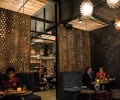 Preview of Mamnoon Restaurant - Image 5: Person, Furniture, Dining Room, Dining, Couch, Dining Table, Wood Screen, Wood, Exposed Structure, Steel, Structure Steel, Light Fixture, Exposed Duct, Brick, Restaurant.