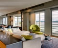 Preview of Market Condo - Image 0: Great room, Furniture, Chair, Dining Table, Table, Indoors, Interior Design, waterfront, concrete structure, exposed structure, lighting, Couch, House, Carpet, Concrete, Steel, Window, Glass, Waterfront, Condominium, Wood.